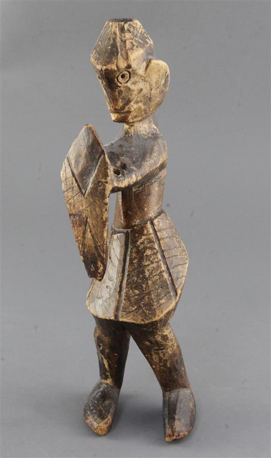 An African carved softwood figure of a man holding a shield, 31cm